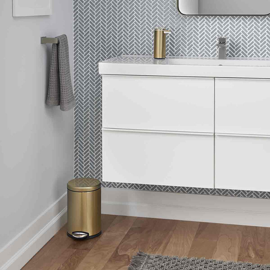 Lifestyle view of Simplehuman 4.5L Round Step Can in Brass finish, compact size for modern bathroom, hands-free pedal.
