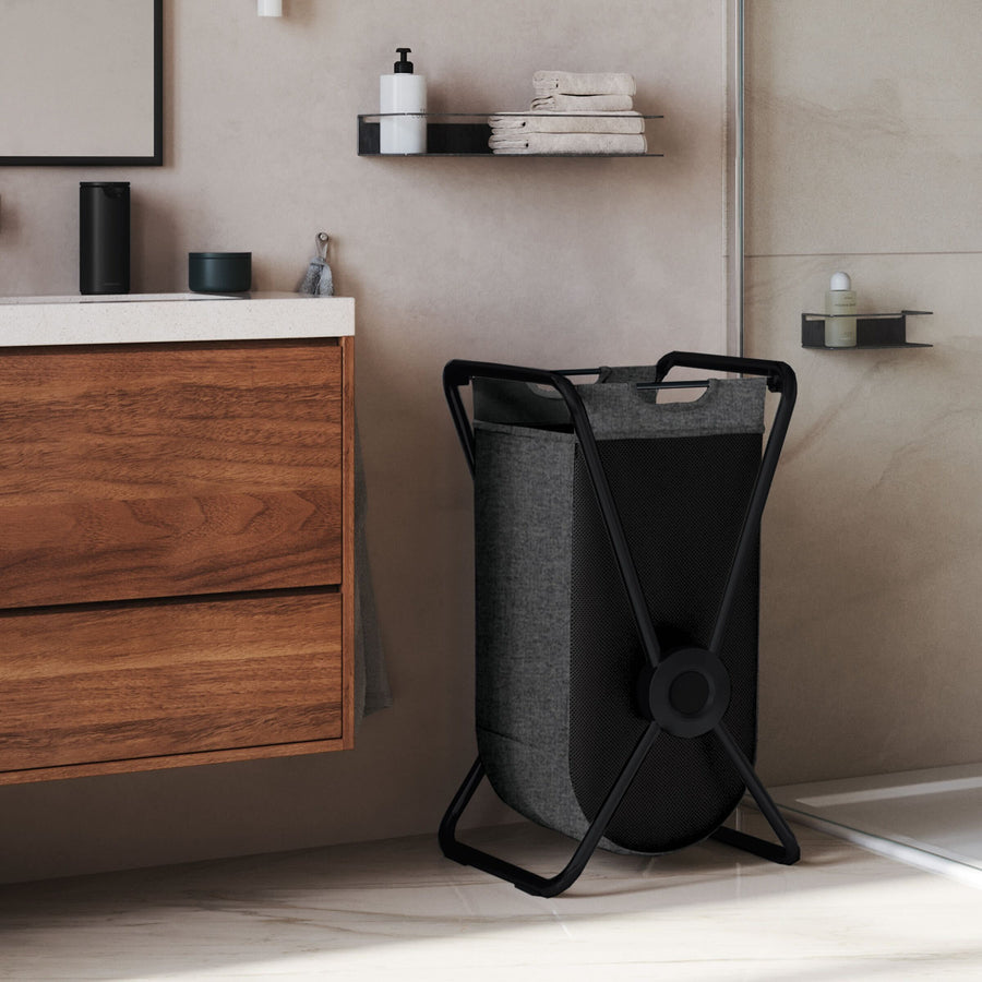 Lifestyle view of Simplehuman Single X-Frame Hamper, Matte Black frame, space-saving design, removable gray mesh liner.