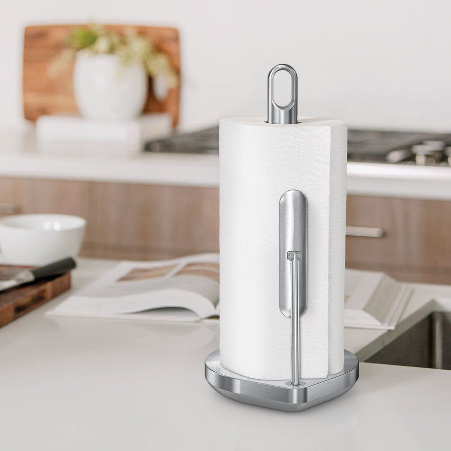 Angled view of Simplehuman Brushed Stainless Steel Tension Arm Paper Towel Holder on kitchen counter.