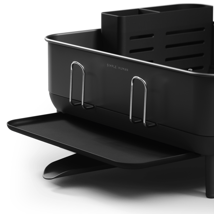 Close-up of Simplehuman Compact Steel Frame Dishrack, Matte Black, highlighting logo, polished steel handles, and extended spout.