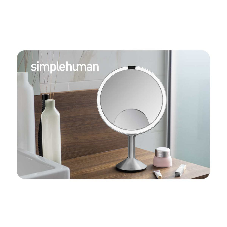 Simplehuman Sensor Mirror in Brushed Stainless Steel on a vanity, auto-on sensor light for perfect makeup.
